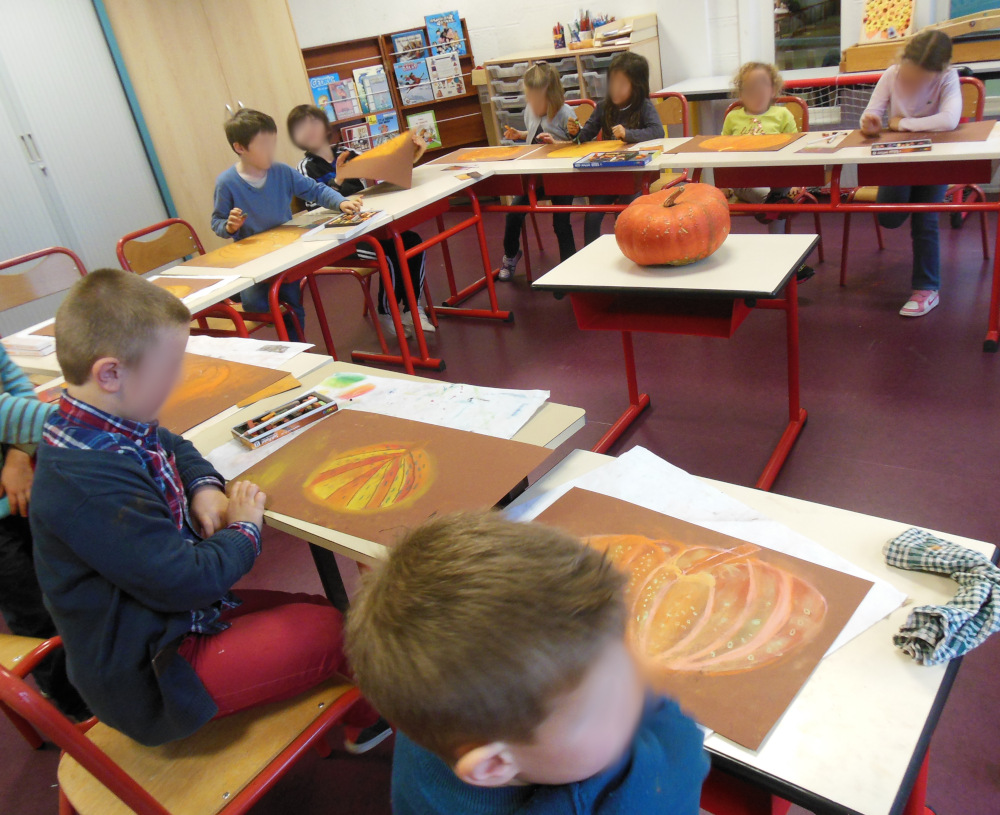 enfants dans une classe autour d'une citrouille pour un atelier de pastel sec
