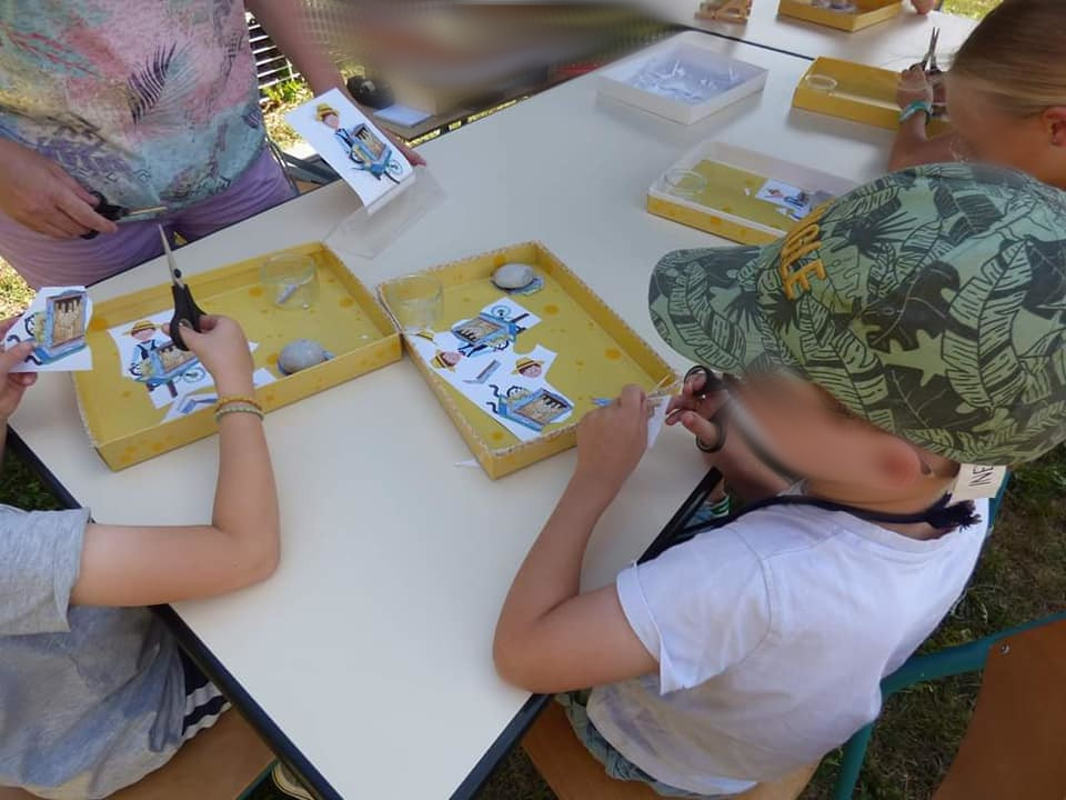 des enfants qui découpent un dessin créé spécialement pour une fete organisées par une ville